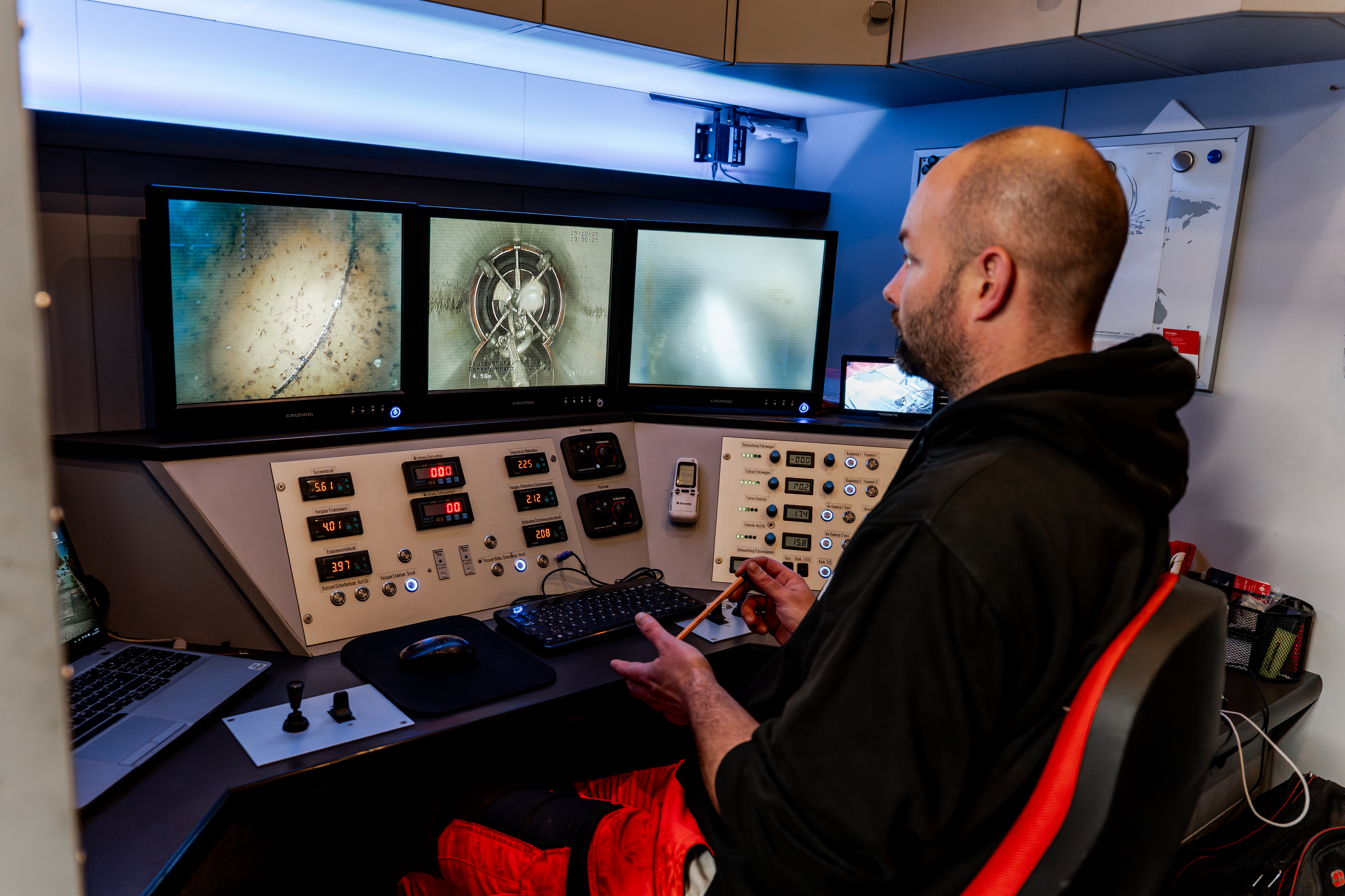 Sanierungsmitarbeiter am Monitor im Fahrzeug